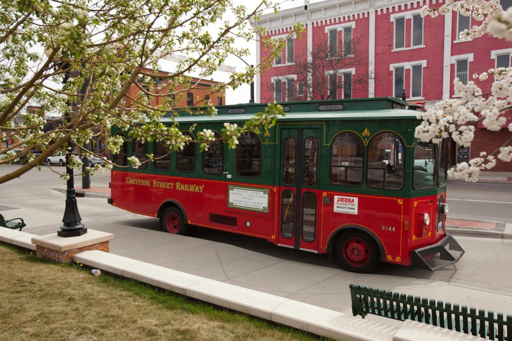 The Cheyenne Street Railway Trolley in front of a row of colorful historic buildings.