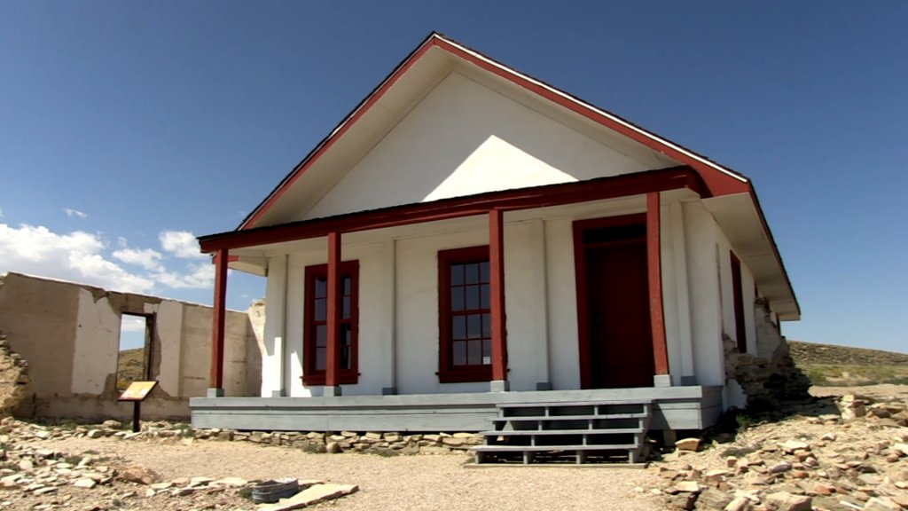 An unassuming white house with red support beams stands at the Fort Fred Steele Historic Site, WY.