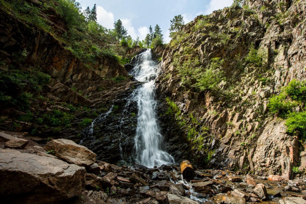 A waterfall cascades through natural terrain and rock in Wyoming.