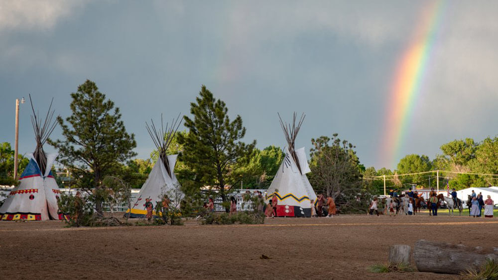 rainbow over teepees at a festival
