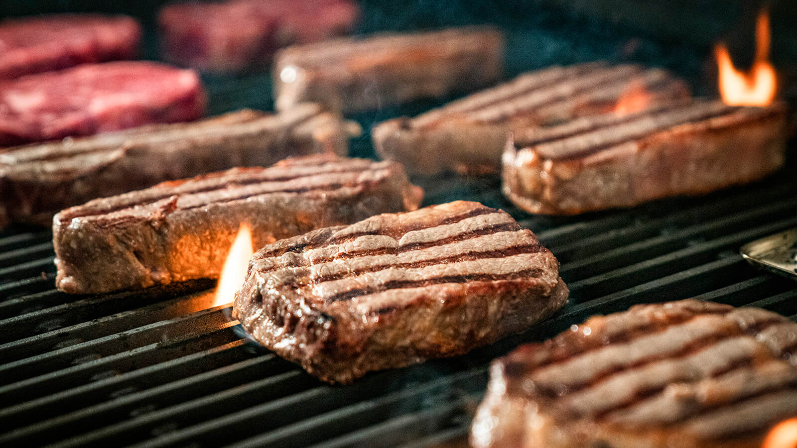 steak grilling on open flame
