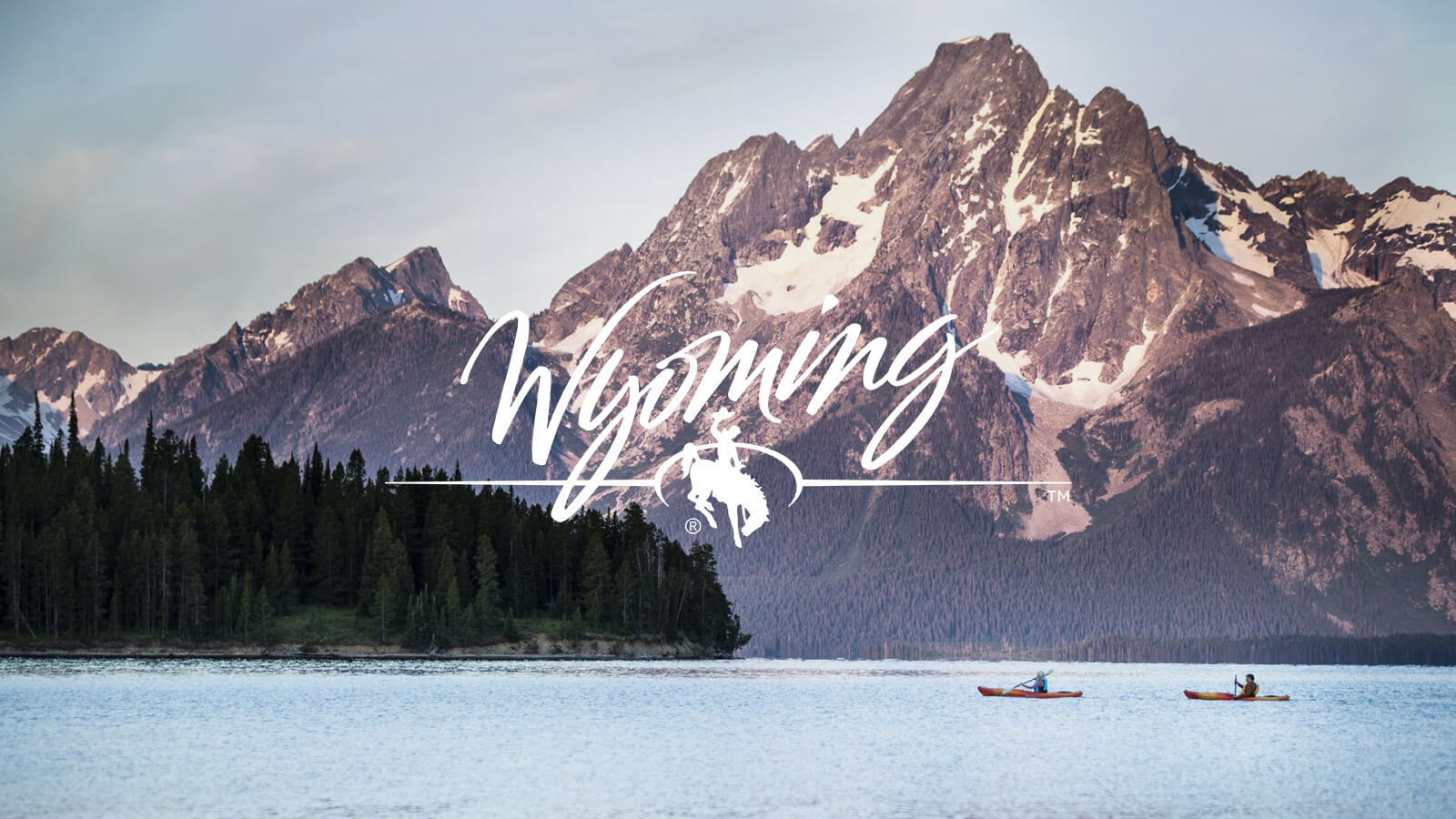 Wyoming logo on image of two kayakers paddling in front of the Tetons in Wyoming.