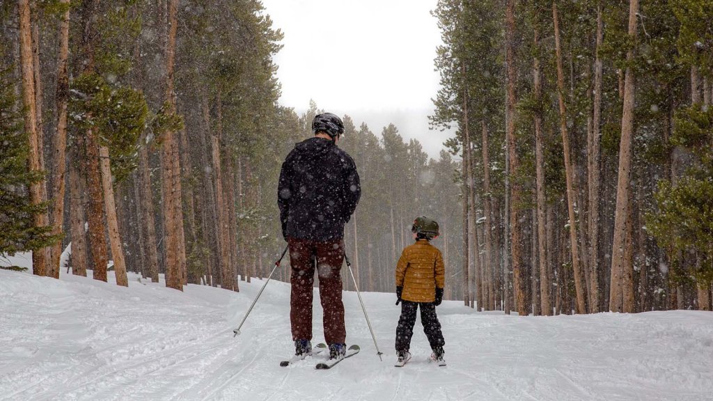 A family enjoying skiing in Wyoming's winter weather, dressed in proper winter outerwear.