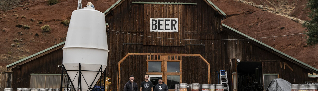Beer barn with beer crafting products and three men.