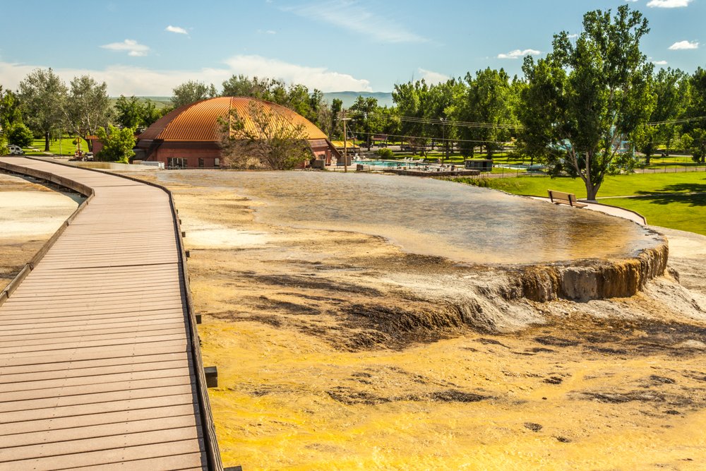 A footbridge snakes across Teepee Fountain, a popular natural hot spring located in Wyoming's Hot Springs State Park.