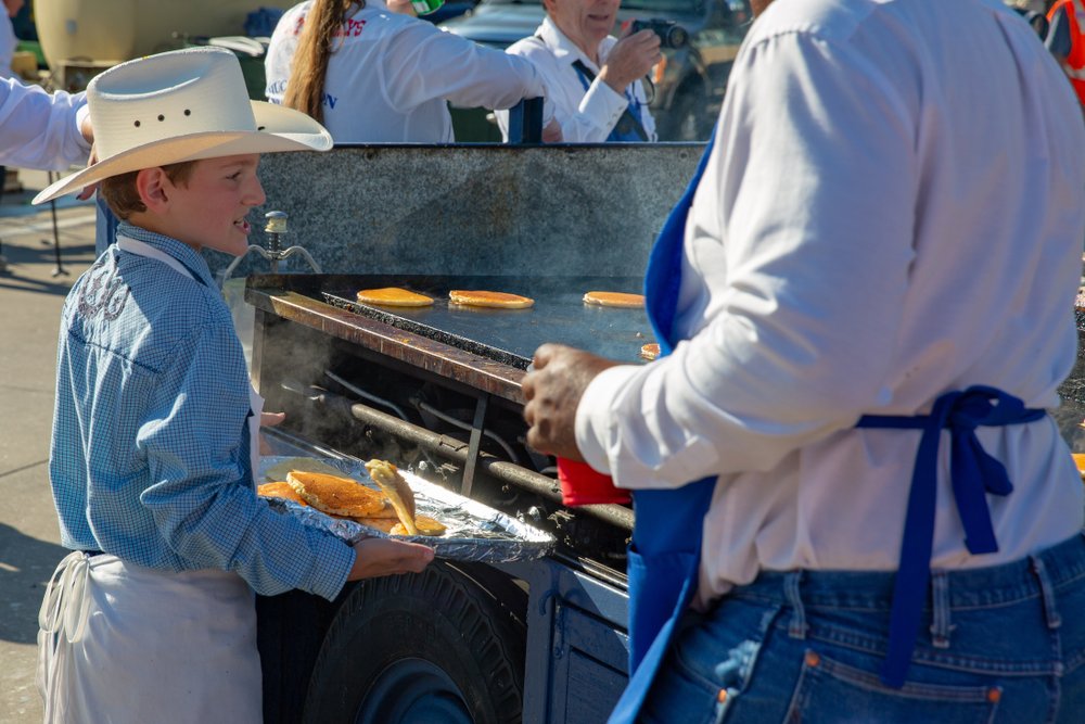 Boy scout helping catch pancakes during Frontier Days in Cheyenne, WY