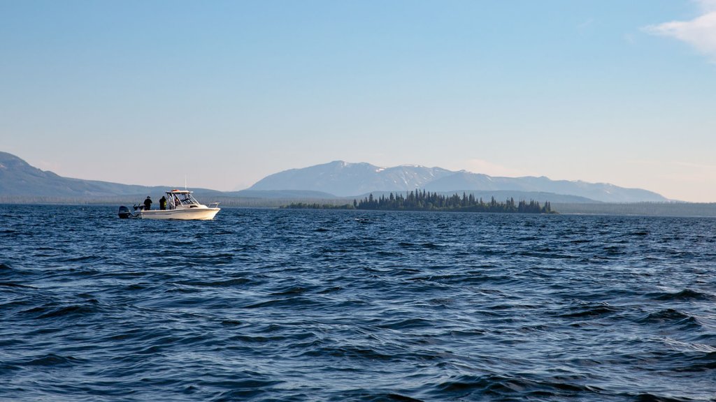 Boating, a top thing to do, in the middle of Yellowstone Lake with mountains and trees in the background