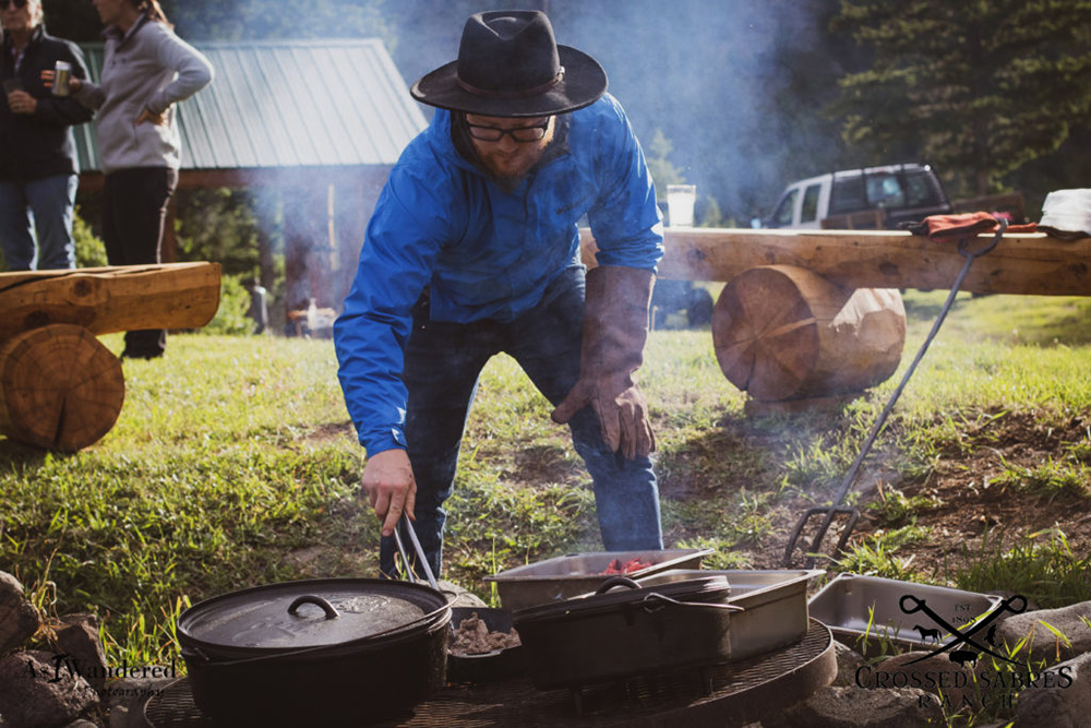 A man grilling food outside a dude ranch in Wyoming