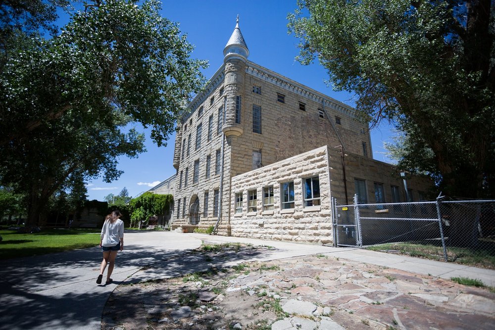 A woman walking up to the historic Wyoming Frontier Prison.