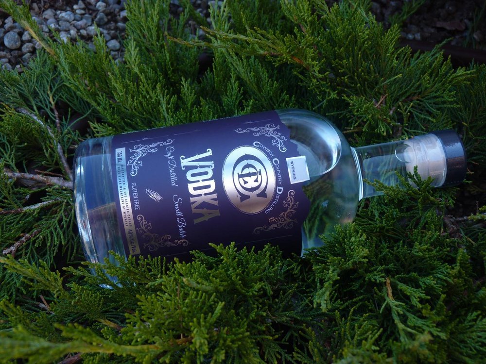 Cowboy Country Distilling brand vodka bottle laying on greenery 