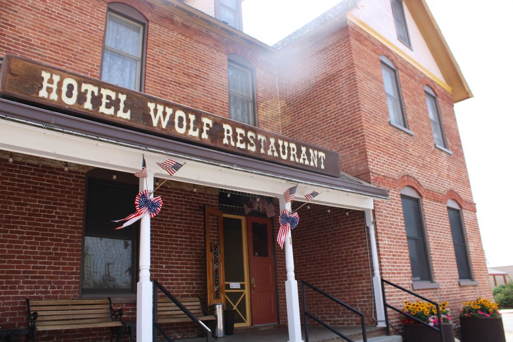 An outside view of the brick Hotel Wolf Restaurant building and a sign that says Hotel Wolf Restaurant.