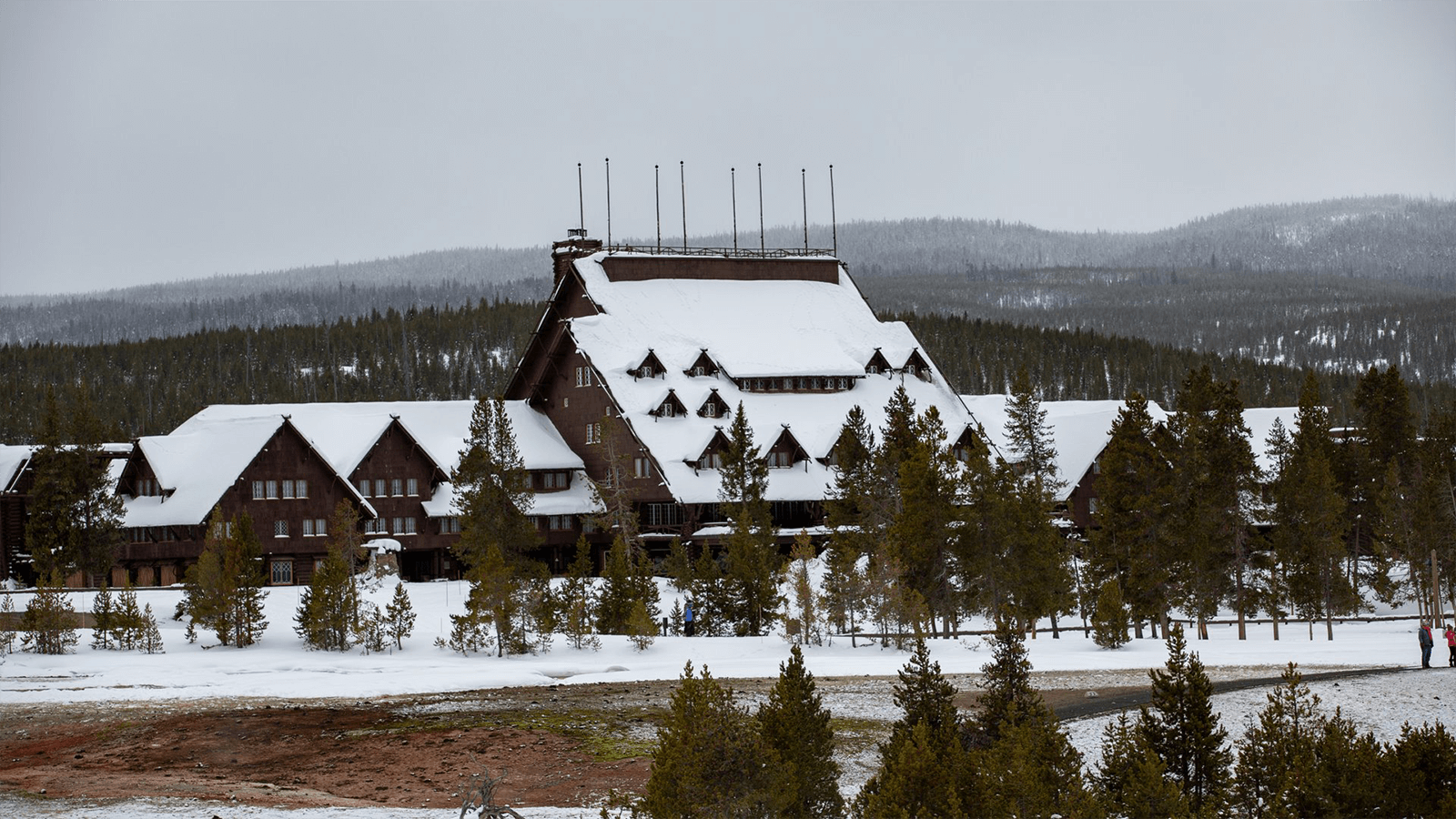 The Old Faithful Inn, a cozy lodge at Yellowstone, adorned with fresh snowfall.