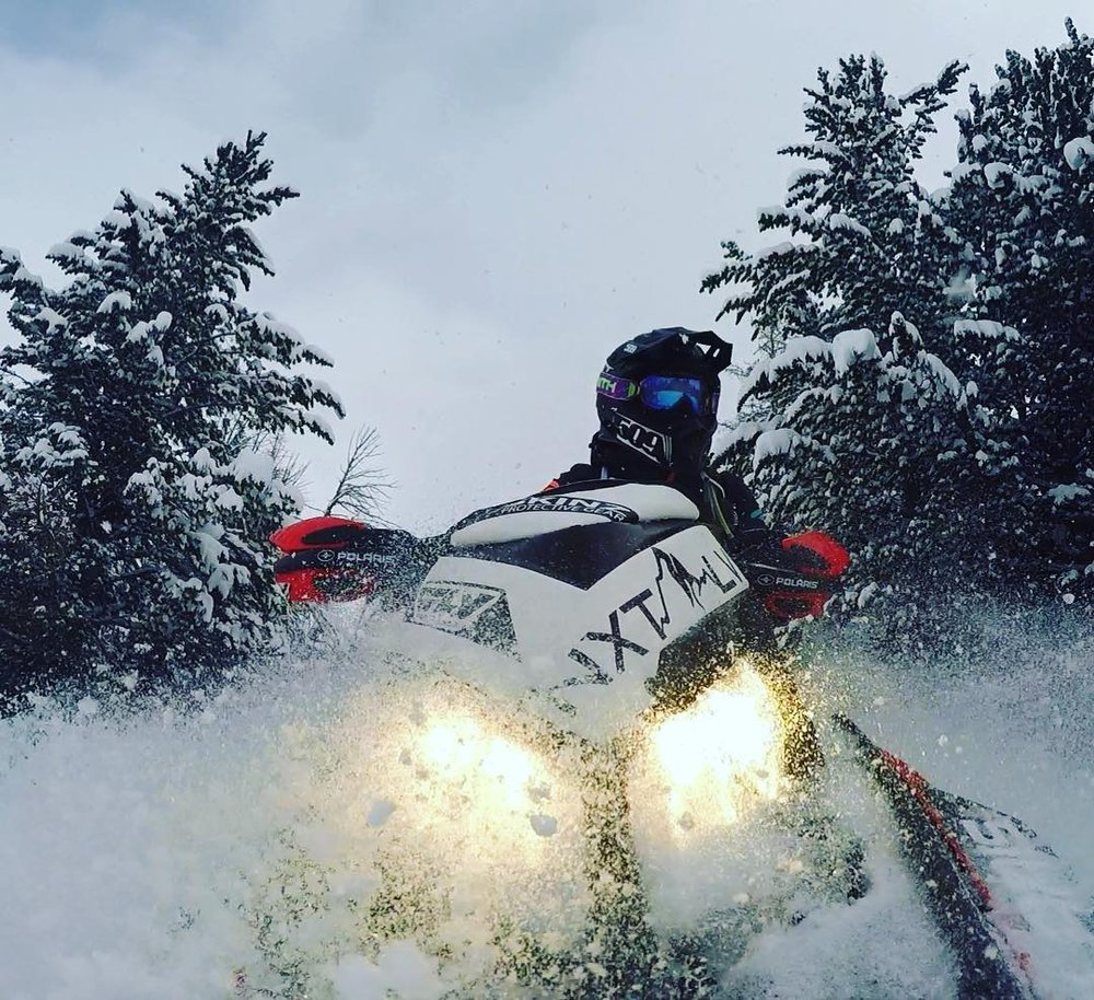 A snowmobiler kicks up snow in Yellowstone National Park.