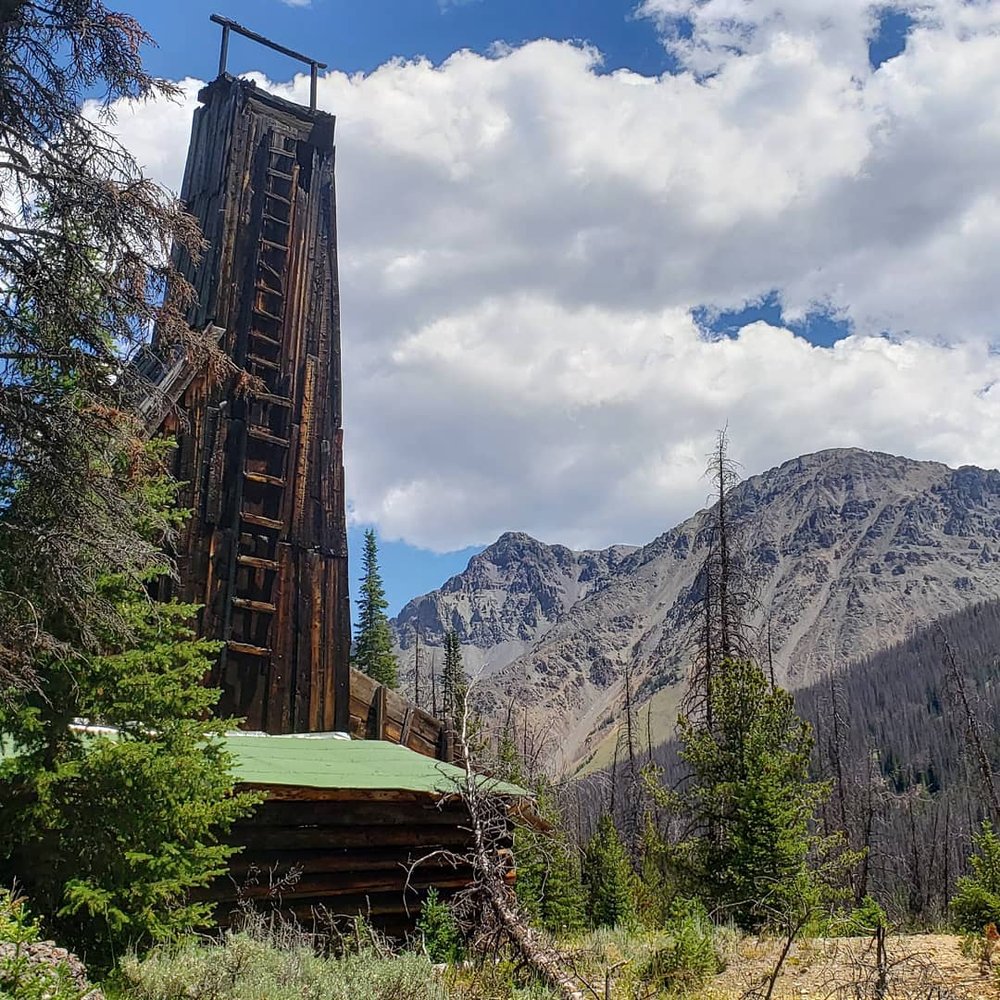 An original log structure with a dreamy mountain landscape in Atlantic City, a ghost town in Wyoming. 