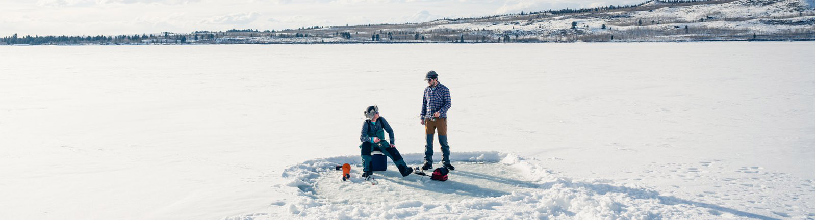 two ice fisherman on frozen lake