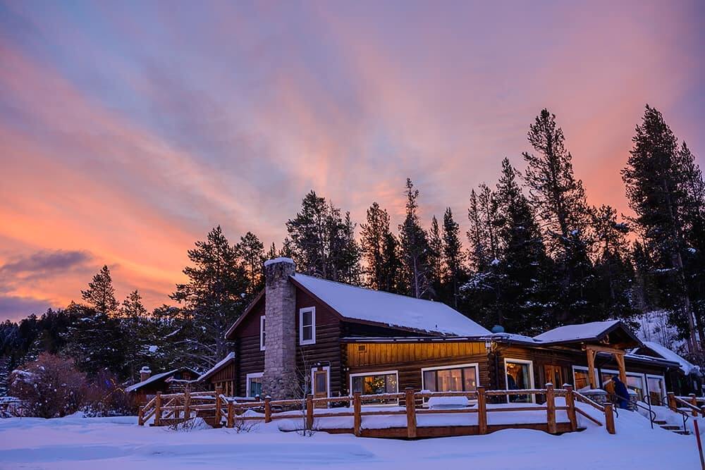 A cabin and a sunset within Grand Teton National Park during the winer 