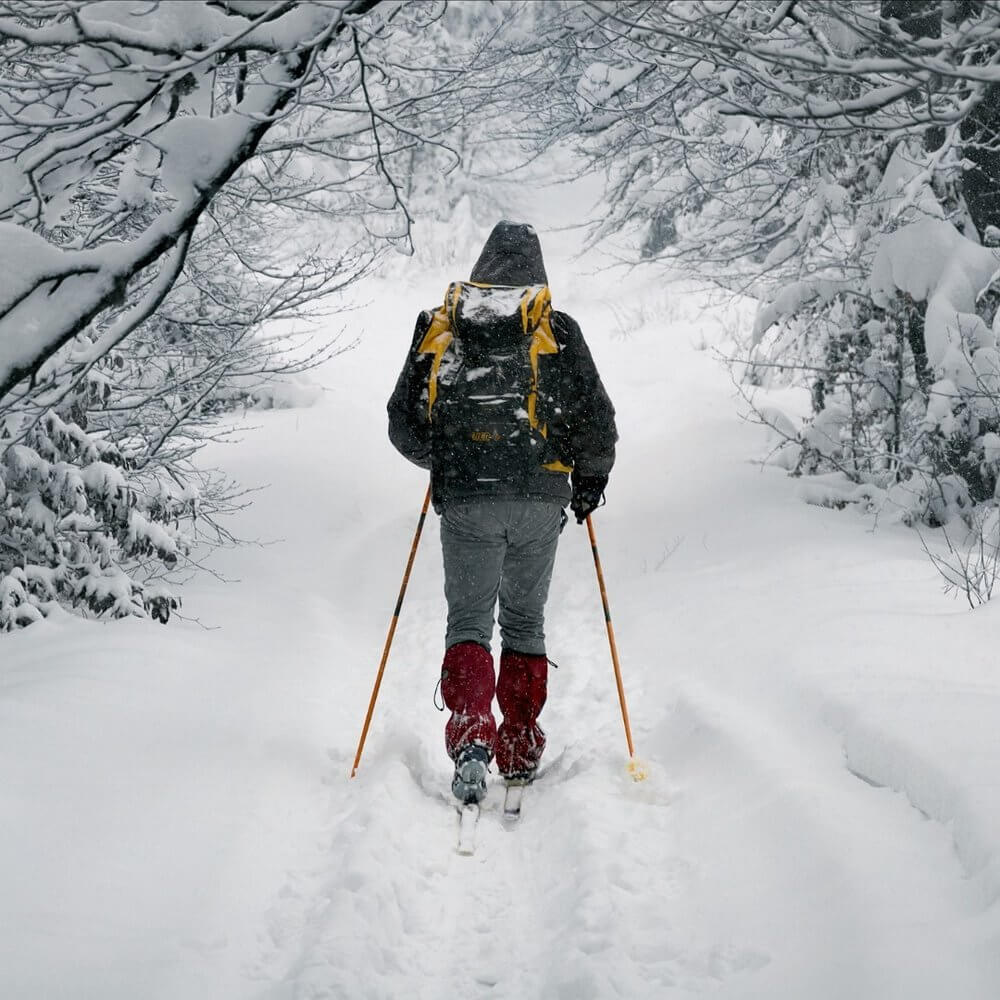 A person snowshoeing through a trail at Grand Teton National Park during the winter 