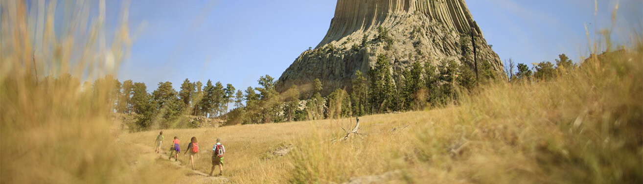 Family of four hiking a trail by Devils Tower.