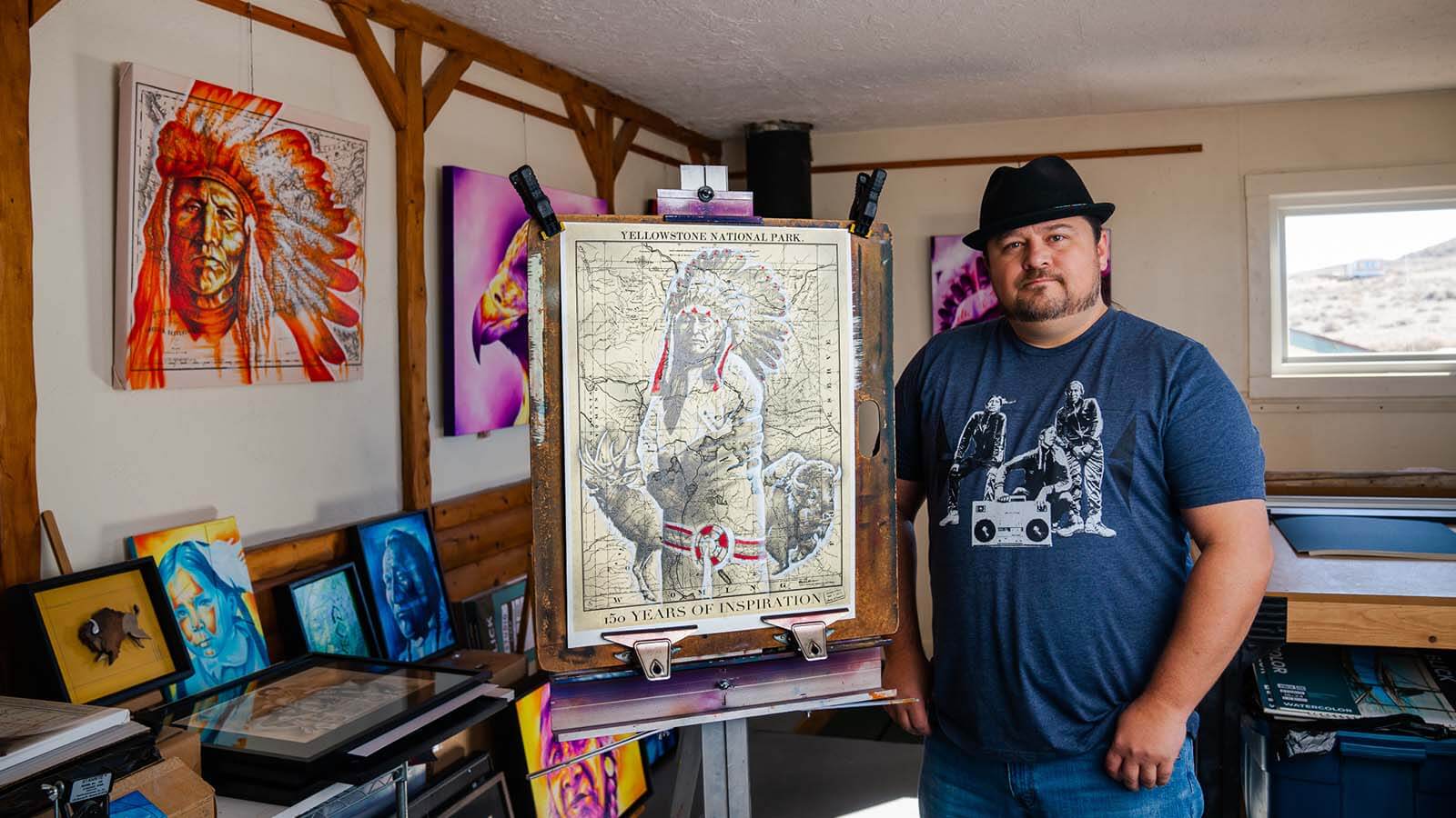 Wyoming Artist Robert Martinez standing with some of his art.