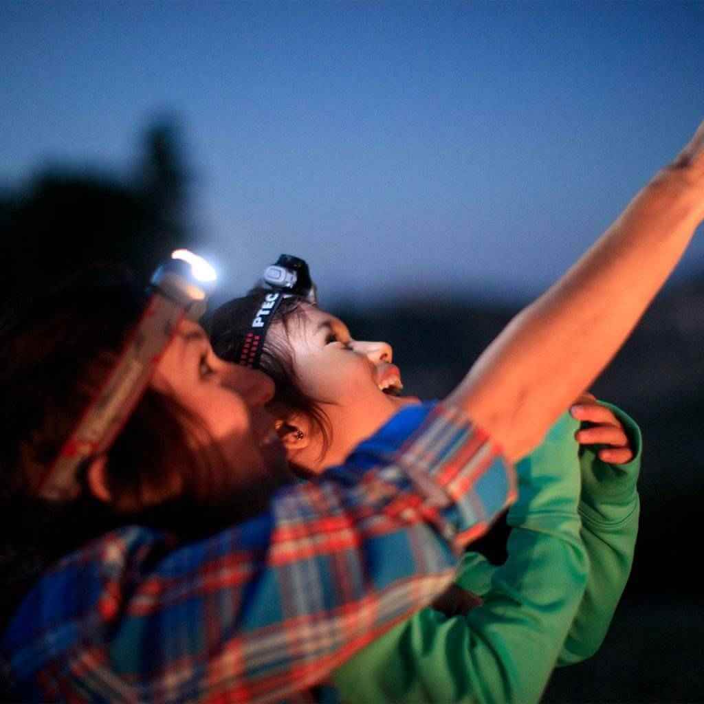 Family laughs while going stargazing, one of the many benefits of traveling together.
