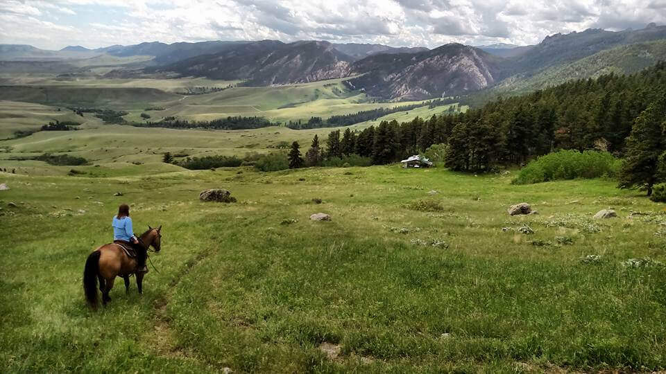 A girl on horseback explores the natural wildnerness of Buffalo, WY, one of the top things to do. 