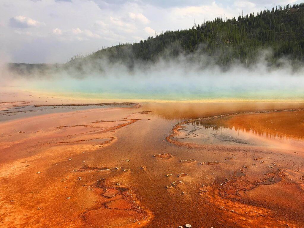 Steam rises above the multi-colored Grand Prismatic Spring in Yellowstone, a top attraction for visitors.