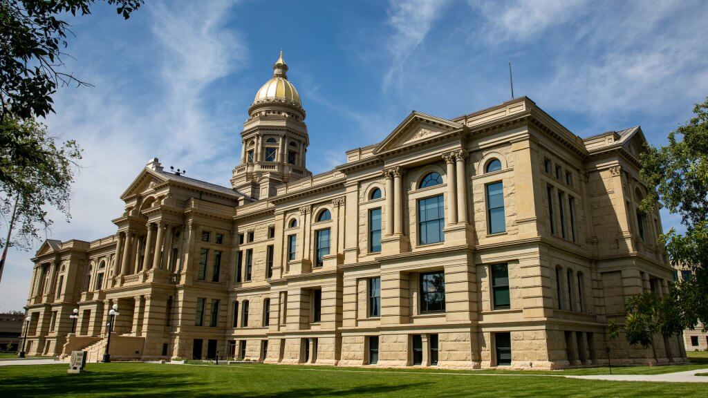 Wyoming's State Capitol sits atop lush lawns under a blue sky, near some of the best things to do around Cheyenne.