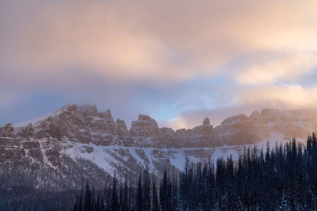 A scenic sunset view of a snowy portion of mountain range. 