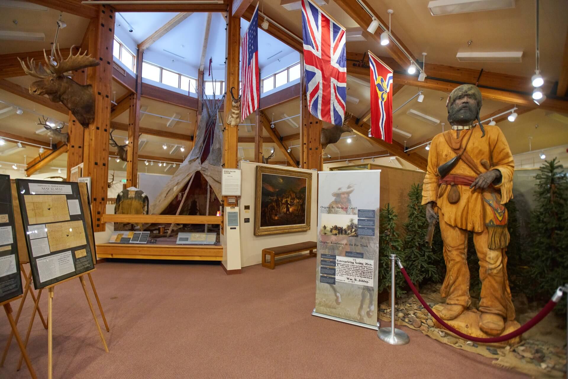 A view of the exhibits and flags inside of the Museum of the Mountain Man.