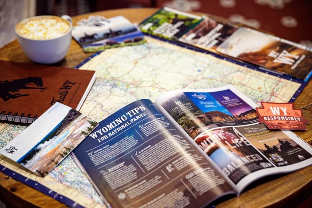 The Wyoming Travel Guide atop a map.
