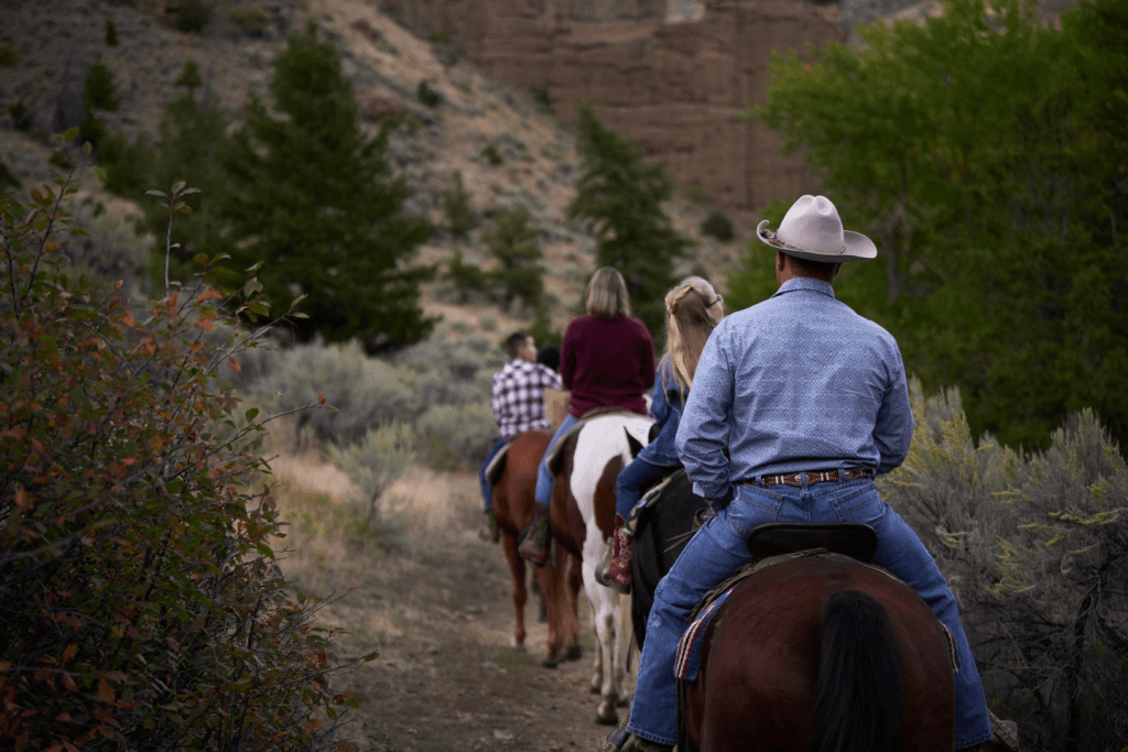 A family rides horseback across four horses on a Wyoming ranch. 