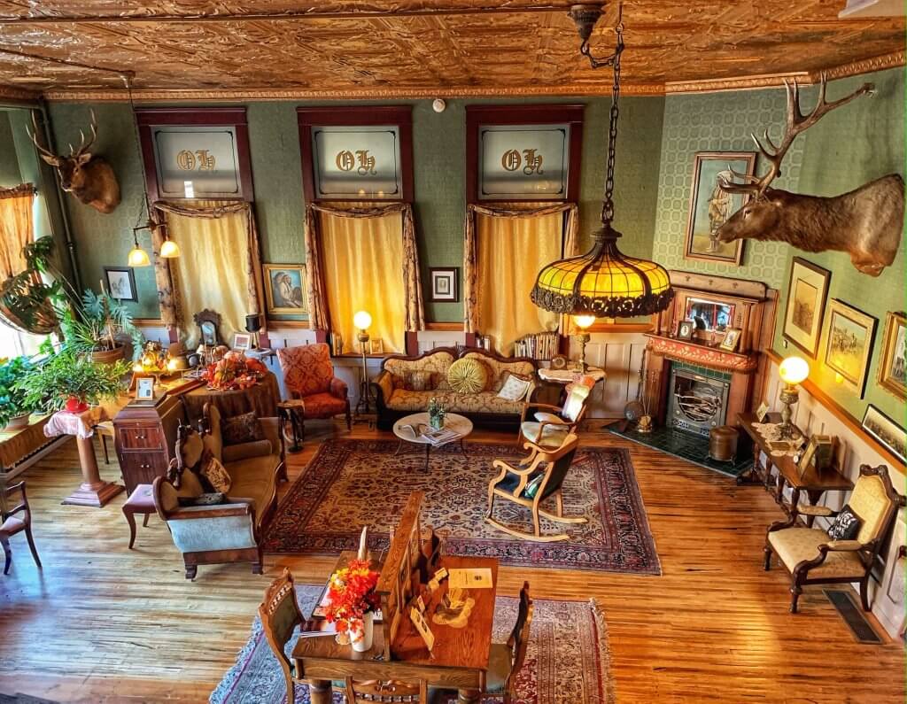 A look inside "The Ox," the Historic Occidental Hotel in Buffalo, Wyoming, where legendary guests once stayed, like Buffalo Bill Cody, Teddy Roosevelt, and Calamity Jane. Inside, you can see old rocking chairs in a colorful space, where a moose head hangs on the wall. 