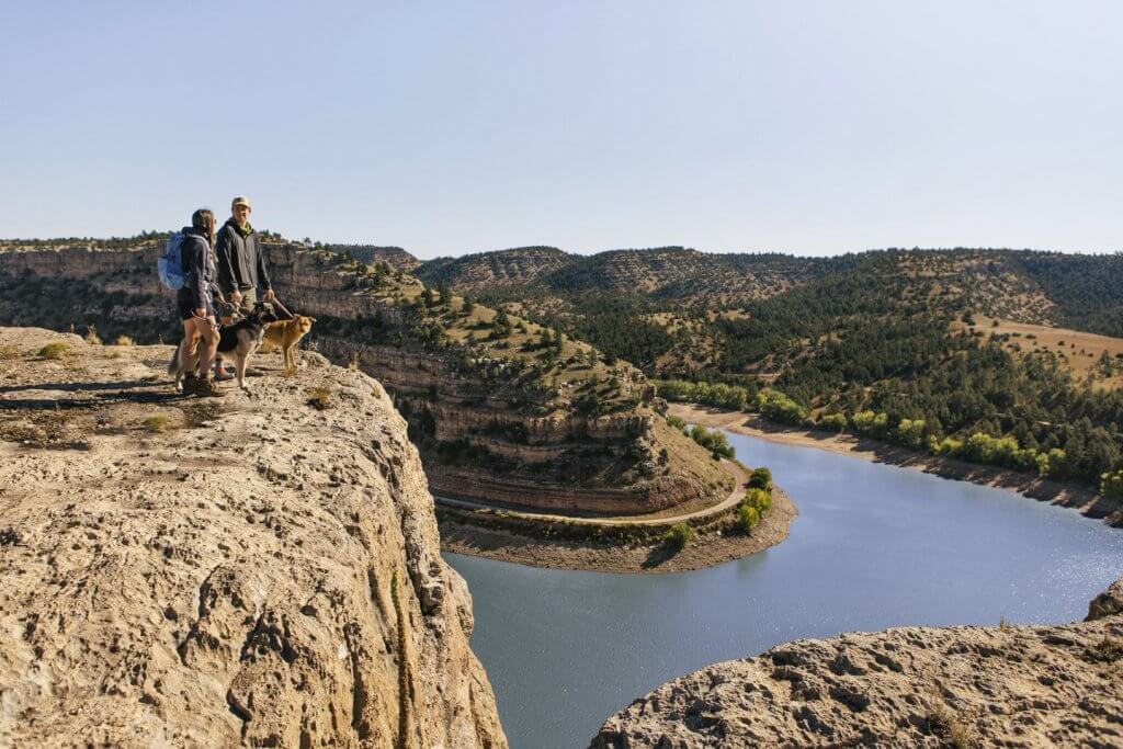 A couple walking their dogs smile at each other as they overlook Register Cliff, standing 100 feet above the sparkling North Platte River valley. 