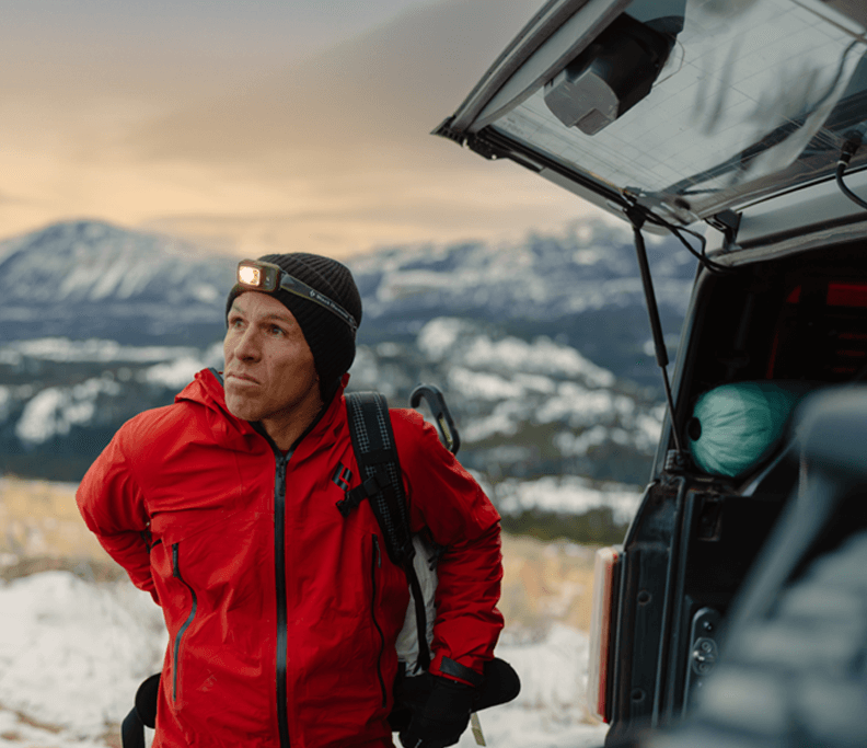 Aaron Mulkey in a red jacket and hat standing in the snow Cody Wyoming