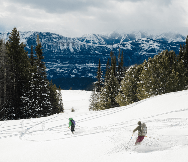 a group of people skiing down a mountain in Cody Wyoming