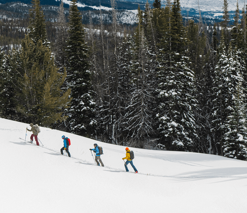 a group of people back country skiing on a snowy mountain in Cody Wyoming